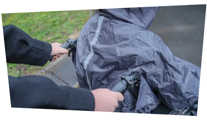 Le vêtement de pluie complet  protège bien le dos et laisse accessibles les poignées du fauteuil roulant